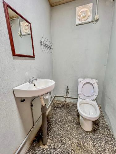 a bathroom with a toilet and a sink at Betik Garden Home in Machang