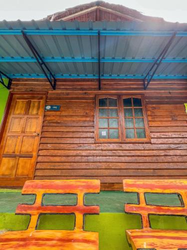 a wooden house with a bench in front of it at Betik Garden Home in Machang
