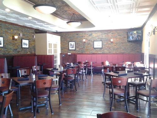 a restaurant with tables and chairs in a room at Americas Best Value Inn Romulus/Detroit Airport in Romulus