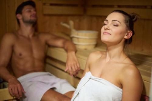 a man and a woman sitting in a bath tub at Strandhotel Kurhaus Juist in Juist