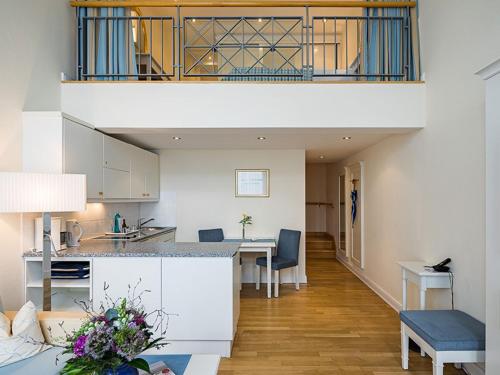 a kitchen and living room with a table and a counter at Strandhotel Kurhaus Juist in Juist