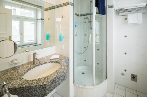 a bathroom with a sink and a shower at Strandhotel Kurhaus Juist in Juist