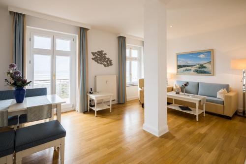 a living room with a couch and a table at Strandhotel Kurhaus Juist in Juist
