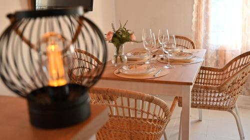 einen Esstisch mit Stühlen und einen Tisch mit Weingläsern in der Unterkunft Casa Rural Antigua Botica in Torremocha de Jarama