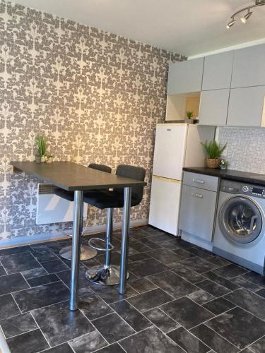 Attleborough的住宿－1 Bedroom Apartment - Bedworth Nuneaton Coventry，厨房配有桌子、洗衣机和烘干机