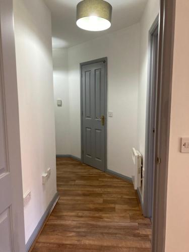an empty hallway with a door and wooden floors at 1 Bedroom Apartment - Bedworth Nuneaton Coventry in Attleborough