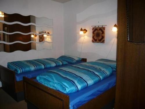 a bedroom with a bed with blue sheets on it at Haus-Sonnenbichl-Wohnung-102 in Oberstdorf