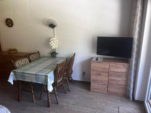 a dining room with a table with chairs and a television at Haus-Sonnenbichl-Wohnung-102 in Oberstdorf
