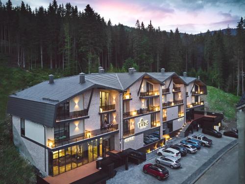 a large house with cars parked in front of it at Twins Hotel & Spa in Bukovel