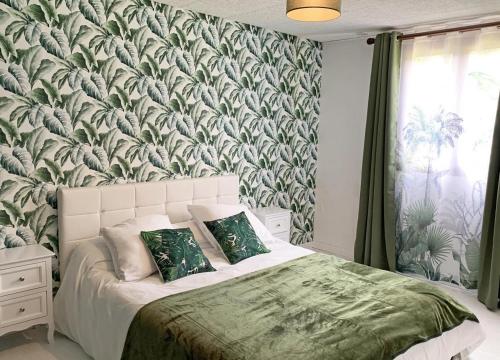 Schlafzimmer mit einem Bett mit einer grünen und weißen Tapete in der Unterkunft Le Camp Brousse 