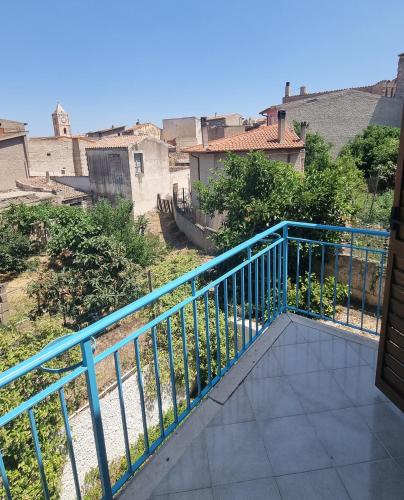 a balcony with a blue railing and some buildings at Giardino Dei Limoni Apartment in Oliena