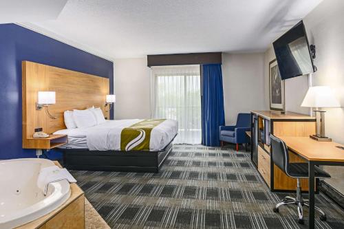 Quality Inn في بورن: غرفة الفندق بسرير ومغسلة
