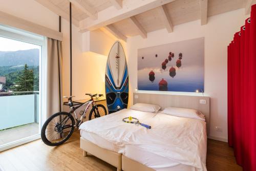 a bedroom with a bed and a surfboard on the wall at Energy Hotel in Calceranica al Lago