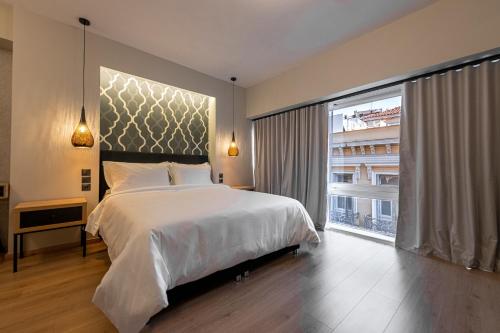 a bedroom with a large bed and a large window at Ethereal Athεns in Athens