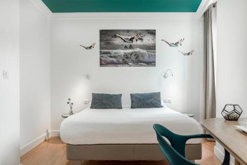 um quarto com uma cama e uma secretária com uma cadeira em The Originals Boutique, Grand Hôtel de la Gare, Toulon em Toulon