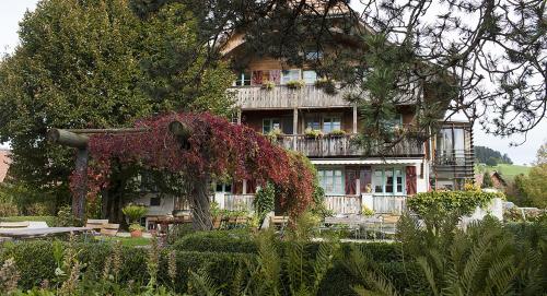 a large house with a lot of flowers in front of it at Bio Garni Möschberg in Grosshochstetten