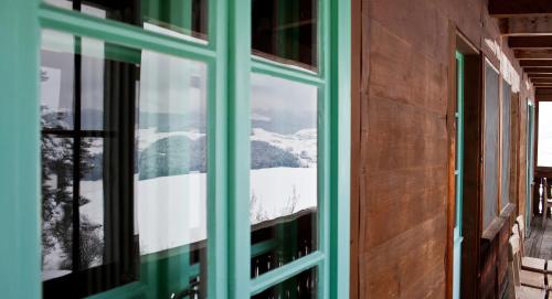 a view of a snowy mountain through a window at Bio Garni Möschberg in Grosshochstetten
