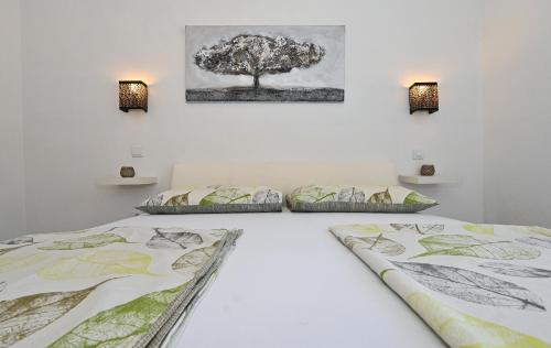 - 2 lits dans une chambre avec un arbre sur le mur dans l'établissement Apartments Villa Filip, à Trogir