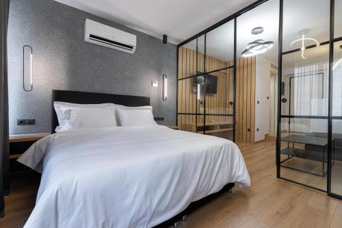 a bedroom with a large white bed and glass walls at Ethereal Athεns in Athens