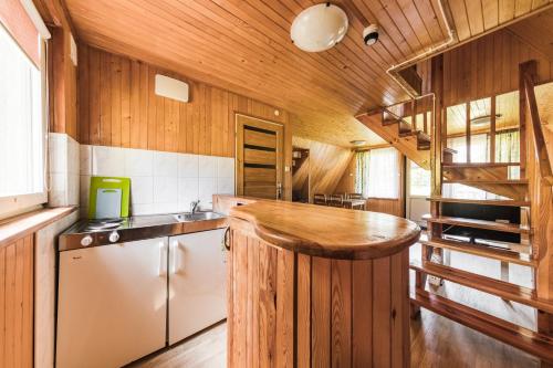 a kitchen with wooden walls and a wooden counter top at Ośrodek Wypoczynkowy Kalwa in Pasym