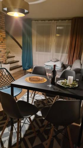 einen Esstisch mit Stühlen und eine Flasche Wein in der Unterkunft Apartamenty Perła Bałtyku in Władysławowo