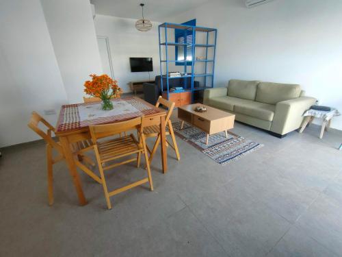 a living room with a table and chairs and a couch at Desert Path in Beʼer Ora