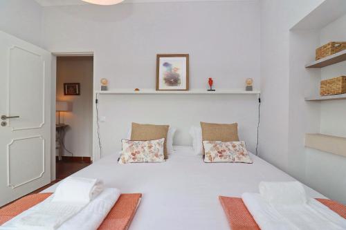 a bedroom with a white bed with two pillows at Casa do Terraço in São Martinho do Porto