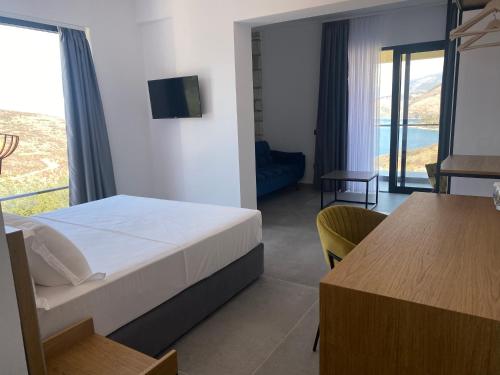 a bedroom with a bed and a view of the ocean at Vila D Boutique Hotel in Qeparo