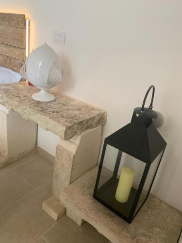 a black lantern sitting on a table next to a bed at Masseria Petra in Martano