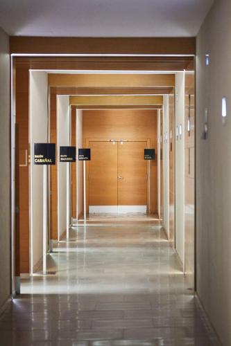 an empty hallway with wooden doors in a building at Silken Puerta Valencia in Valencia