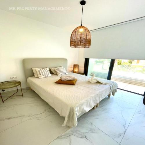 a bedroom with a large bed with a large window at By the Beach Villa 7 in Protaras