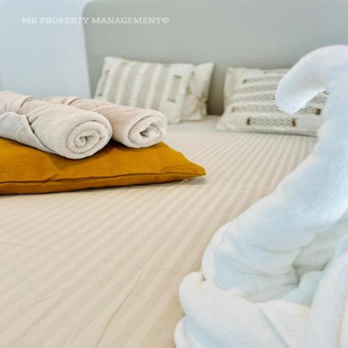 a white bed with towels on top of it at By the Beach Villa 7 in Protaras