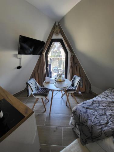 een kamer met een tafel en stoelen op een zolder bij Apartman Krnjajic Diamond Hill in Divčibare