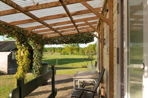 a wooden pergola on a patio with a table and chairs at Chalet Regge in Giethmen