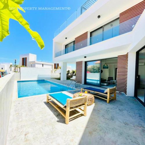 a villa with a swimming pool and a house at By the Beach Villa 7 in Protaras