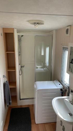 a small bathroom with a shower and a sink at Chalet Regge in Giethmen