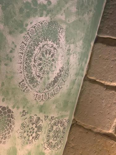 a plate with a mandala painted on a brick floor at Masseria Petra in Martano