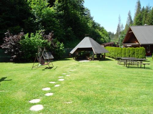 a grassy yard with a gazebo and a table at Chata Sipkova I in Terchová