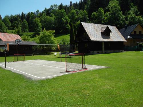 un campo da tennis di fronte a una casa di Chata Sipkova I a Terchová
