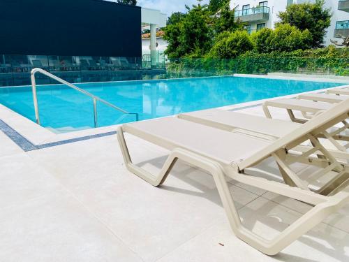 un sillón blanco junto a la piscina en Hotel Silgar 92, en Sanxenxo