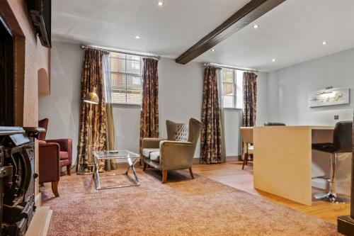 a living room with chairs and a table at Roomzzz Newcastle City in Newcastle upon Tyne