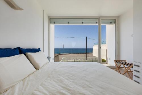 a bedroom with a bed and a view of the ocean at Villa Baia delle Sirene by Perle di Puglia in Leuca