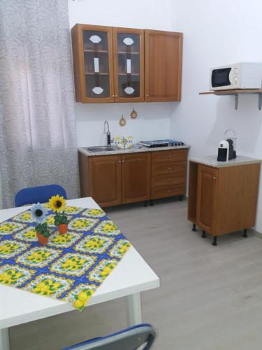 eine Küche mit einem Tisch mit Blumen darauf in der Unterkunft Casa The life in Trapani