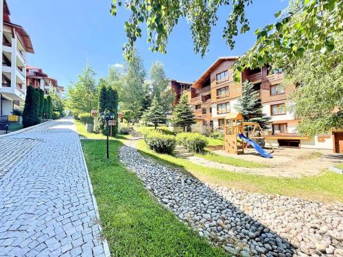 a cobblestone street in front of a building with a playground at Bansko Luxury apartment in St Ivan Rilski Spa 4 Bansko Private SPA & Minreal Hot water pools in Bansko