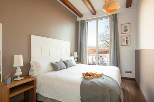 sypialnia z dużym białym łóżkiem i oknem w obiekcie Aspasios Market Balconies w Barcelonie
