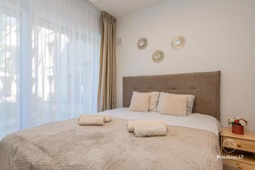 una camera da letto con un letto grande con due cuscini sopra di Apartamentai Malūno vilose a Palanga