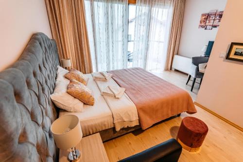 a bedroom with a bed and a large window at Lotos Depandans in Niš