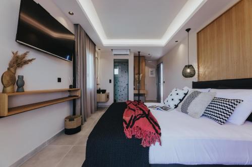 una camera da letto con un grande letto bianco con cuscini di Villa veranda a Plaka