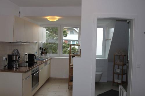 a kitchen with white cabinets and a sink and a window at GROßE-WILDE-BETTEN in Wittdün