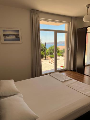 a bedroom with a large bed and a large window at Apartments Angela in Cesarica